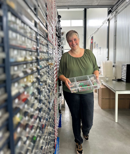 Annelies met een bak LEGO onderdelen in de winkel